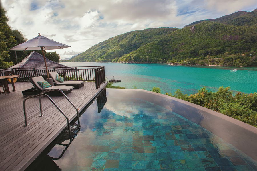 Sunloungers facing a pool which overlooks the Indian Ocean