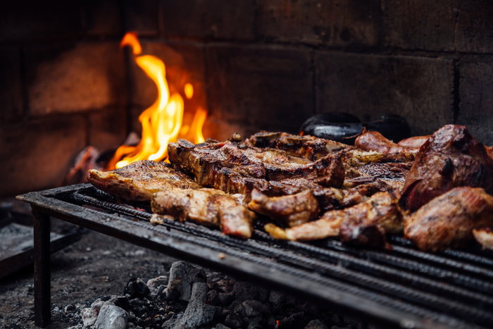 Barbeque, bbq meat cooking on grill. Traditional Asado of Argentina