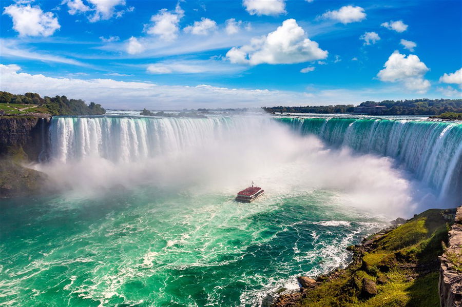 Canadian side view of Niagara Falls, Horseshoe Falls and boat tours in a sunny day in Niagara Falls, Ontario, Canada