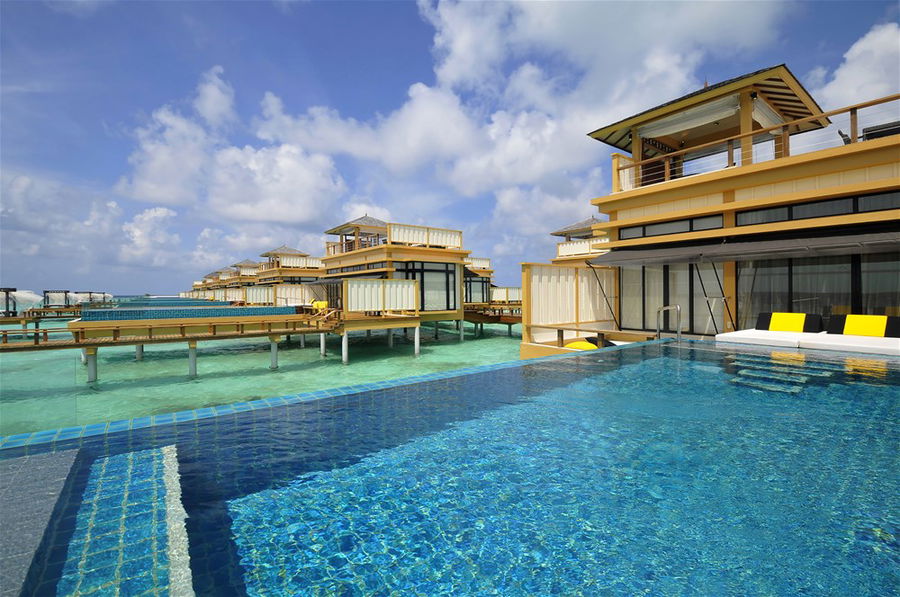 Aerial view of overwater villas at the Angsana Velavaru resort in the Maldives