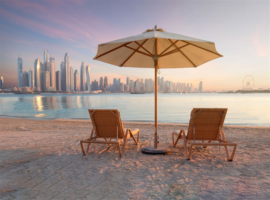 Beautiful Beach In Dubai With 2 Sun Chairs facing the skyscrapers of the city