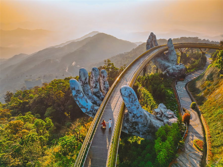 Young traveler couple walking on the Golden Bridge in Bana Hills, Vietnam