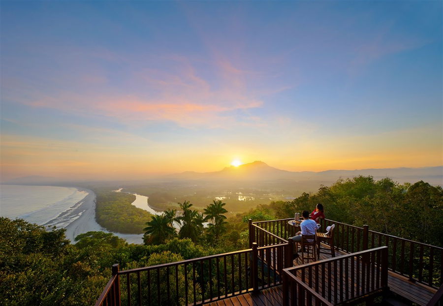 A couple enjoying sunrise from a balcony in Borneo