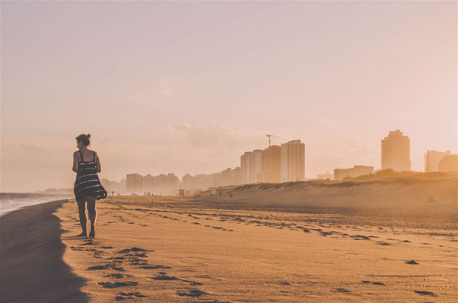 A lone walker on the beach of Punta Del Este at sunset