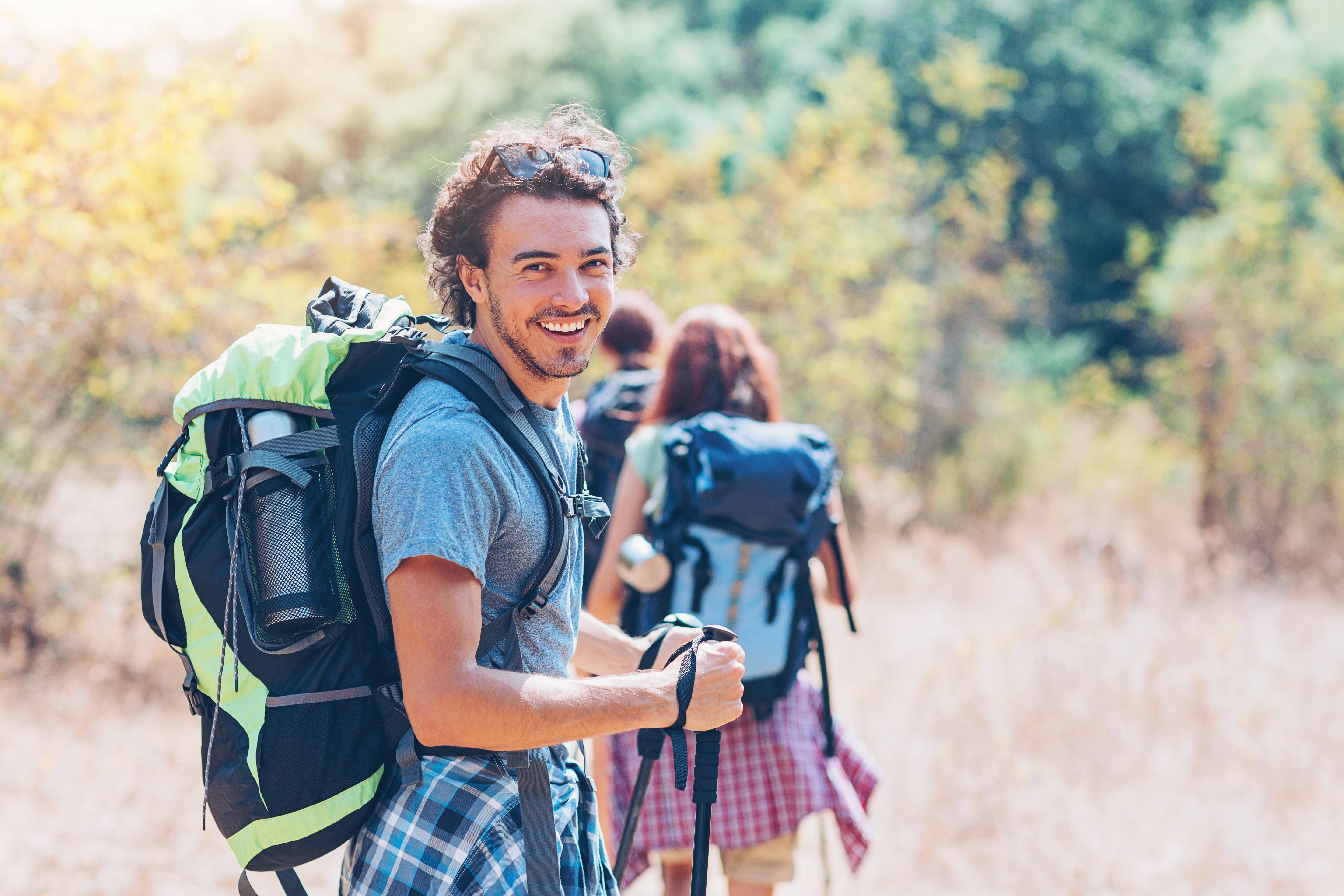 Group of backpackers walking on a footpath in the mountain in the summer