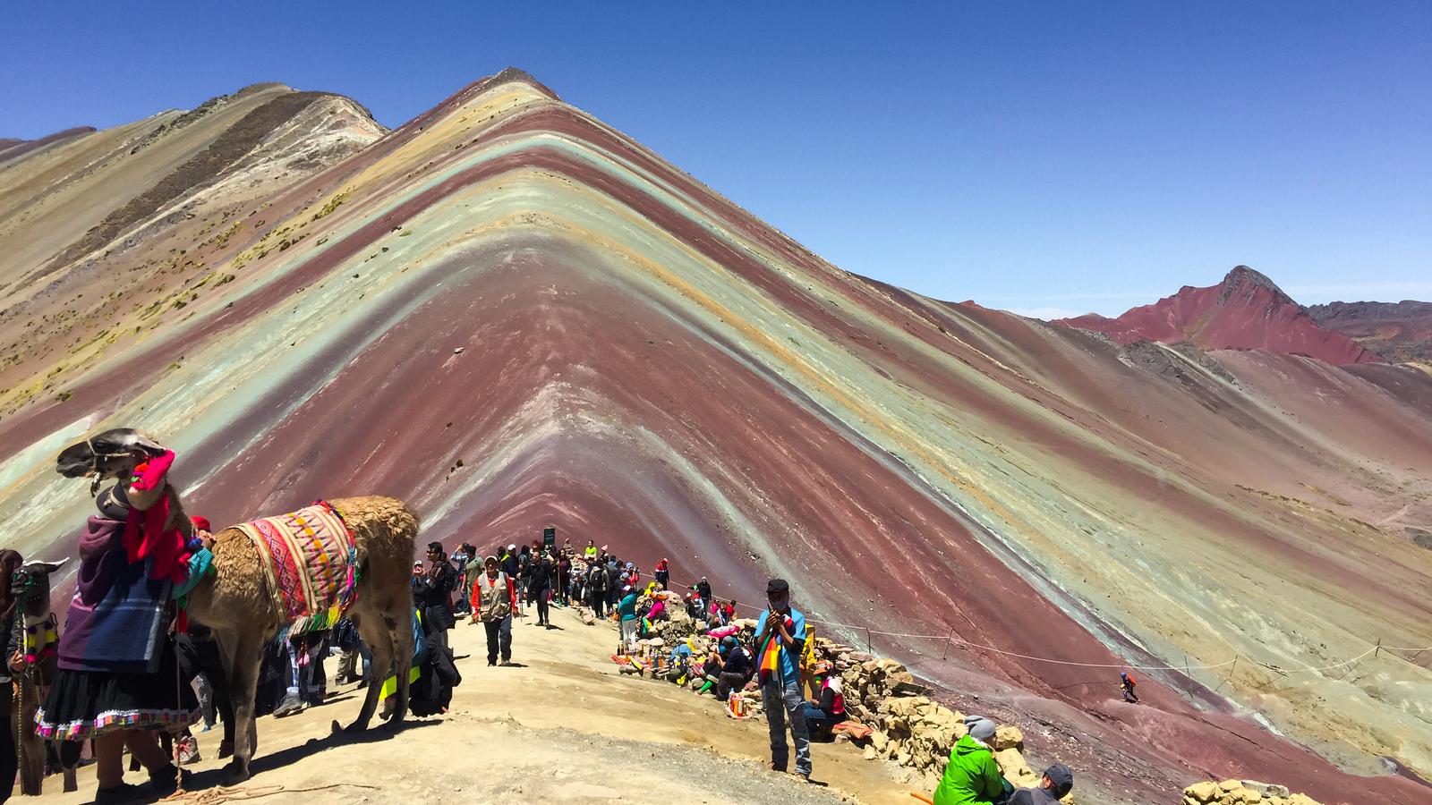 The striking striped colours of the Rainbow Mountain in Peru are contrasted against a bright blue sky