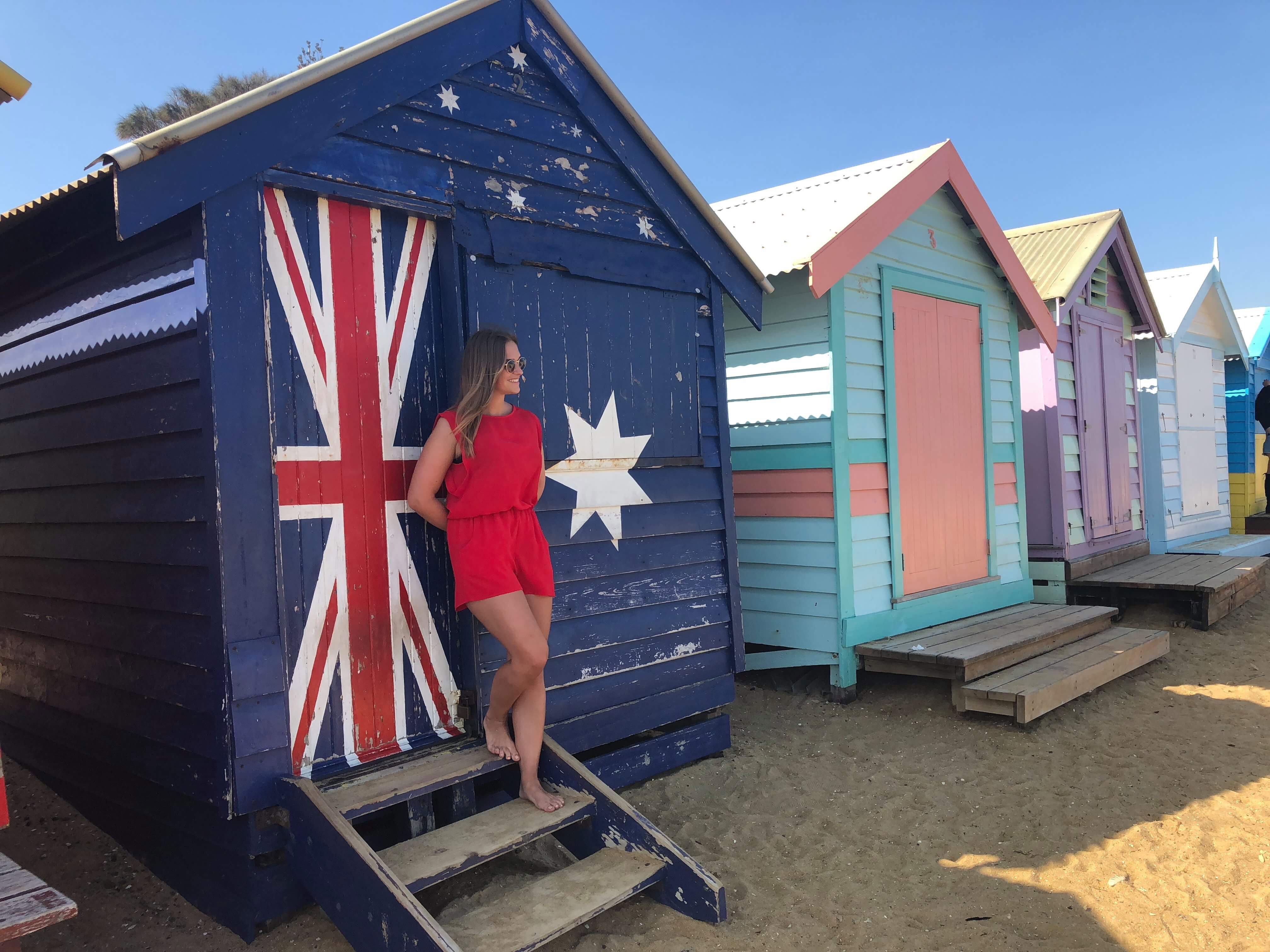 A woman next to beach huts in Melbourne, Australia