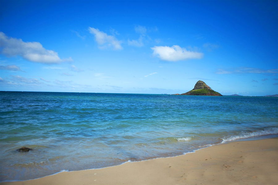 A golden beach and a view out to an island off the shore in Hawaii