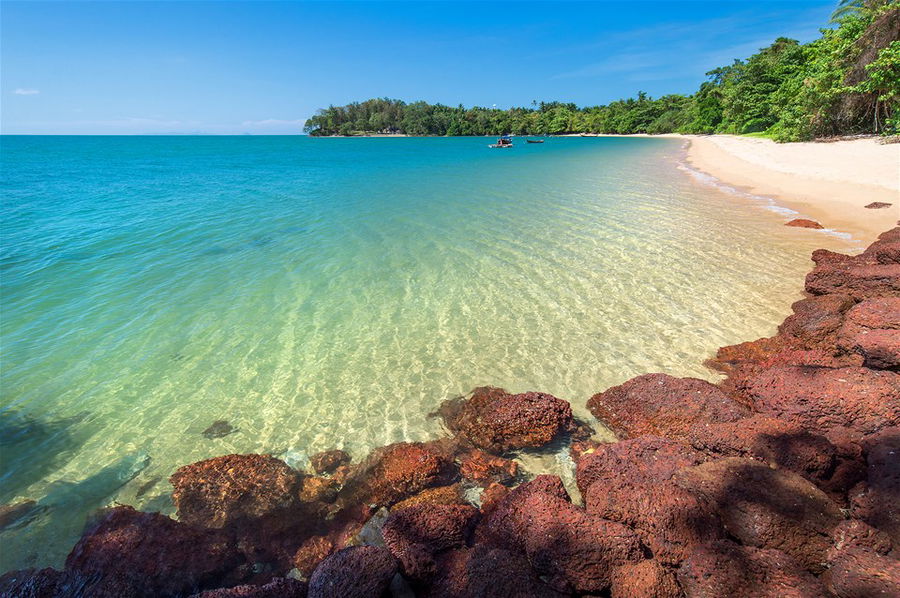 Crystal clear waters lap on a perfect white sand beach in Krabi, Thailand