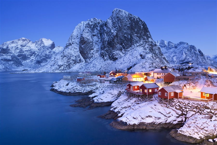 Fisherman's cabins on a snowy peninsula at dusk in Norway