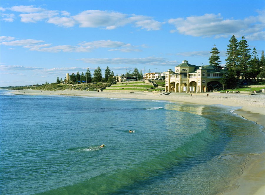 A curved, white sand beach and blue ocean in Western Australia