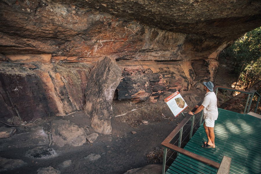 Tourist looking at Aboriginal art Nourlangie, Kakadu National Park