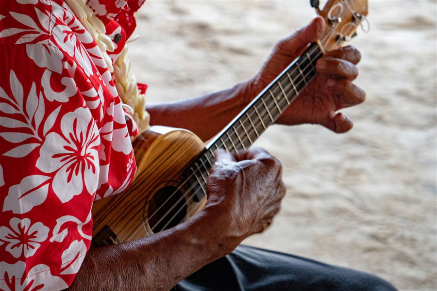 Old man hands playing ukulele in Bora Bora, French Polynesia