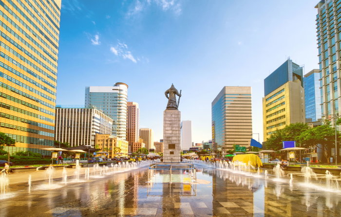Sunset of Gwanghwamun Plaza with the statue of the Admiral Yi Sun-sin and modern buildings in downtown Seoul, South Korea