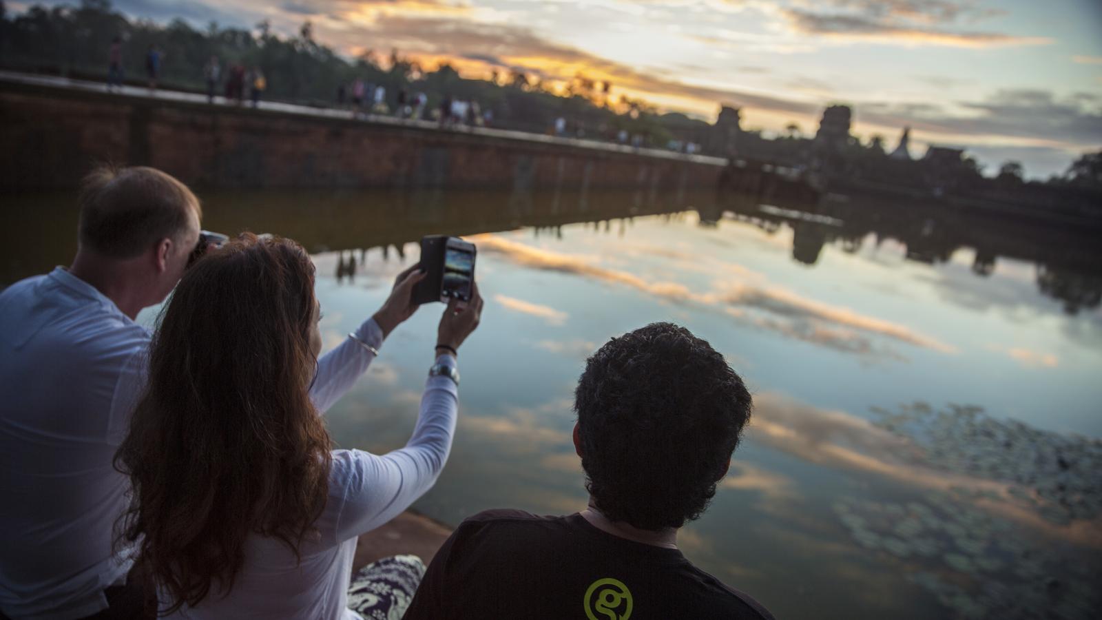 Two people emerging from the ancient stone remains of the iconic Angkor Wat in Cambodia